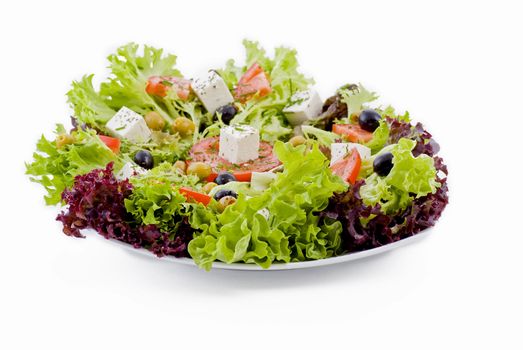 Plate of fresh vegetables - salad, olives, tomato, feta and herbs