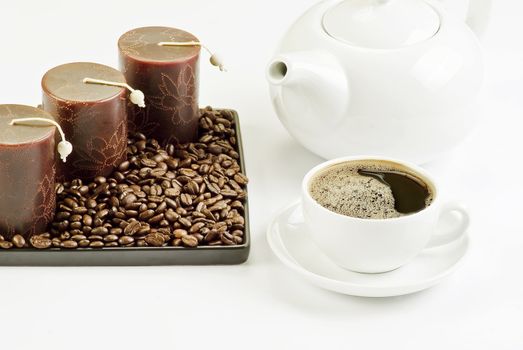 Cup of coffee with coffee beans and candles