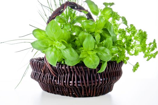 Basket of basil, chive and parsley on white background