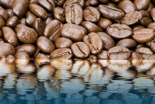Closeup brown coffe beans background texture in water reflection