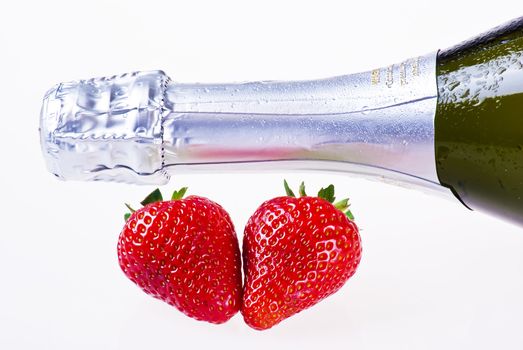 Bottle of champagne and strawberries over white background