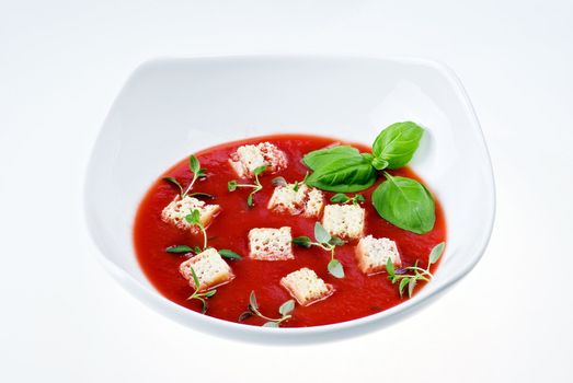 Bowl of tomato soup over white background