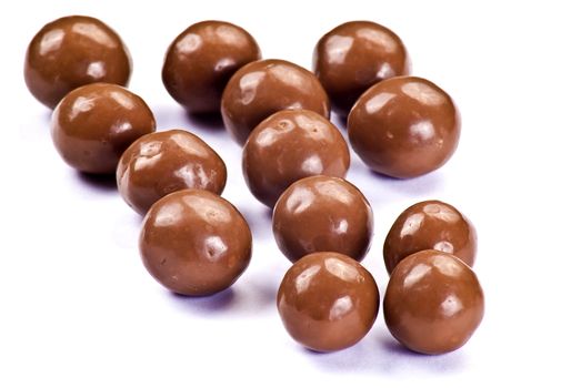 Dark brown chocolate balls over white background