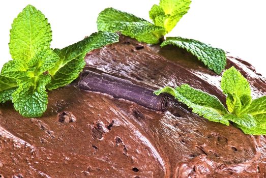 Dark brown chocolate cake and mint leaves - close up