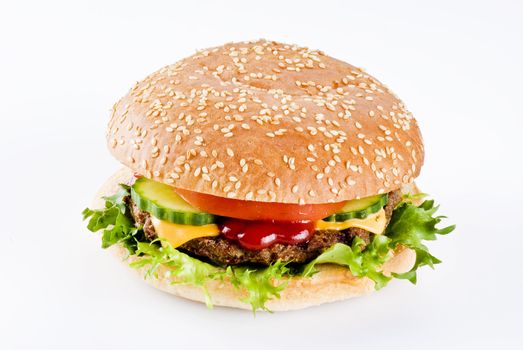 Beefburger in sesame seed bun with vegetables isolated