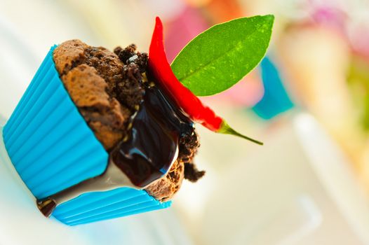 Hot chocolate cupcake with liquid chocolate and a red chili as a outdoor shooting