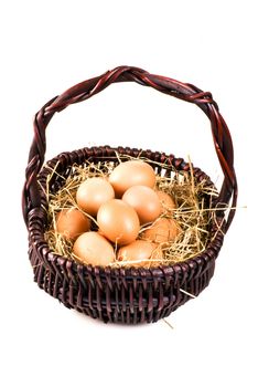 Fresh farm eggs in the basket with hay - isolated
