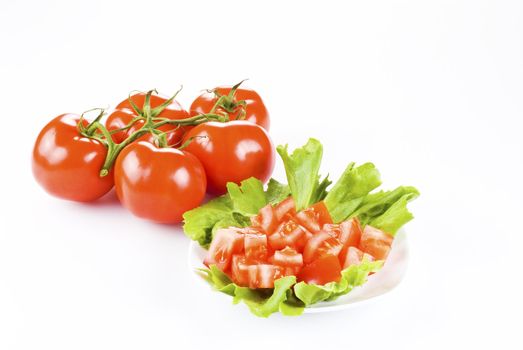 Bunch of tomatoes with one diced on lettuce