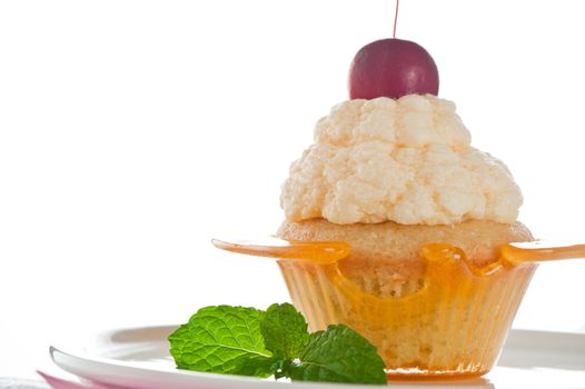 A cupcake in a cup of caramel with vanilla cream on white background