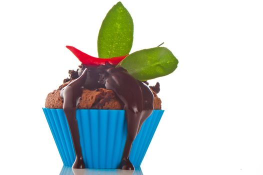 Hot chocolate cupcake with liquid chocolate and a red chili as a studio shooting