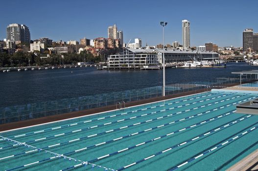 Clear waters of a laned swimming pool alongside an ocean harbour, Sydney, Australia