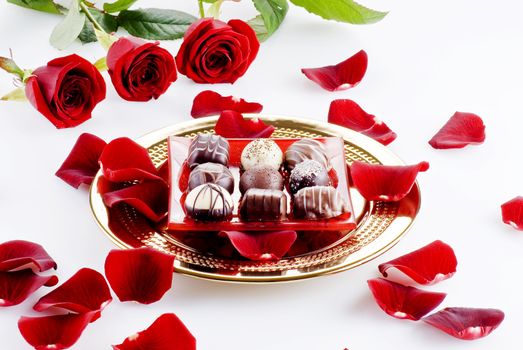 Gold plate of luxury chocolates with red roses