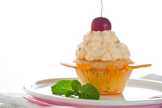 A cupcake in a cup of caramel with vanilla cream on white background