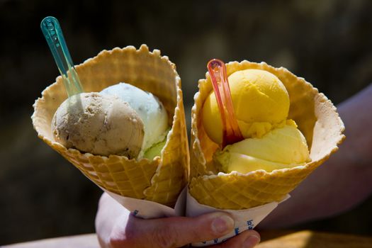 hand holding cones with ice cream