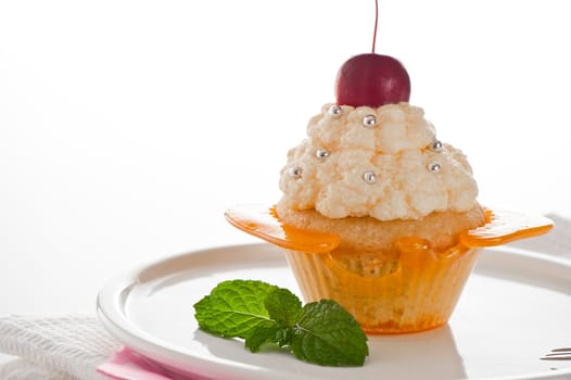 A cupcake in a cup of caramel with vanilla cream on white background