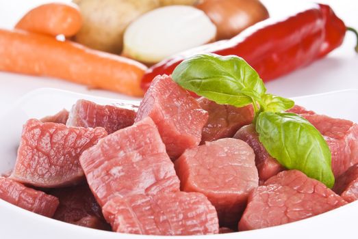 Close up of diced beef with vegetables over white background