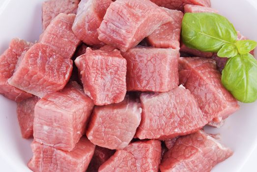 Bowl of diced beef over white background - close up