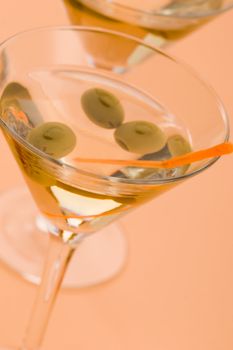 two bocal of martini with olive over yellow
