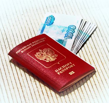 Russian passport in red with gold lettering to go abroad and rubles on a 
beige background