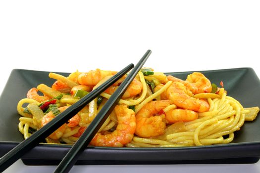 Asian noodles with shrimp and vegetable stir-fry on Asian dishes