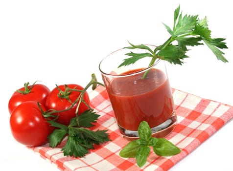a glass of tomato juice with fresh herbs