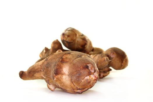 some Jerusalem artichoke tubers in front of white background