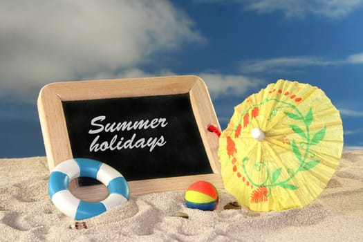 School board and toys on a sandy beach