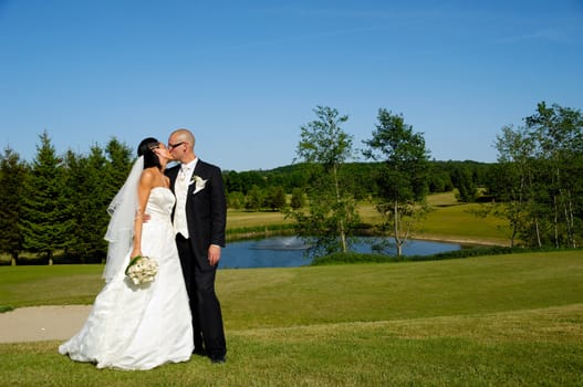 A wedding couple is kissing 