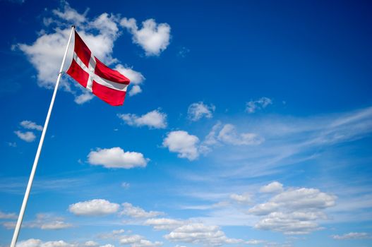 The danish flag and blue and cloudy sky