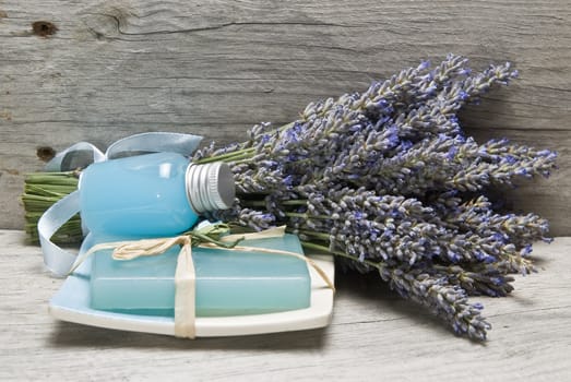 Lavender and some hygiene items made of lavender on an old wooden shelf.