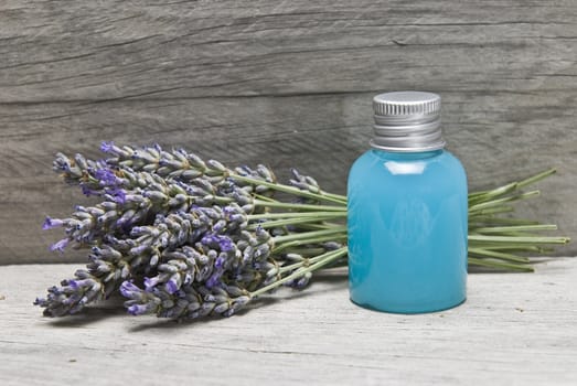 Lavender and some hygiene items made of lavender on an old wooden shelf.