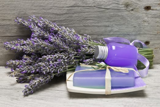 Lavender and some hygiene items made of lavender on an old wooden shelf.