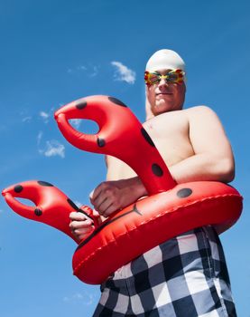 crazy and funny concept of a young man wearing kid's swimming gear