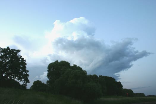 Thundercloud over a flood plain in the late evening