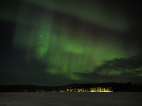 Northern lights (aurora borealis) display over a frozen lake in Lapland.