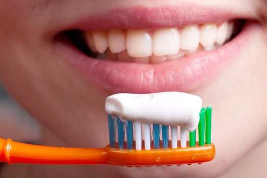 Toothbrush, toothpaste and smiling woman