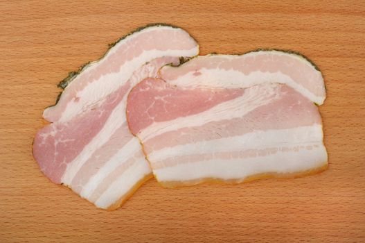 sliced ??bacon on a wooden cutting board