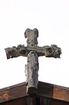 Wooden Cross fixed on a wooden roof isolated on a white background
