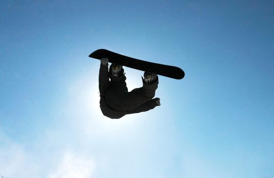 A snowboarder going big high above the half pipe                                