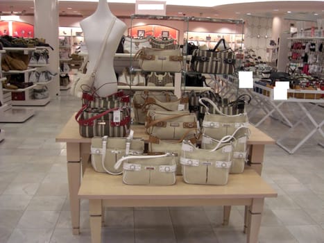 A retail department is displaying a variety of designer handbags in all colors, sizes, and shapes.