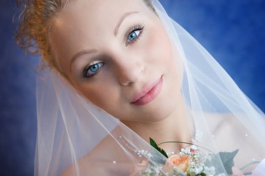 The bride holds a bouquet and pensively looks