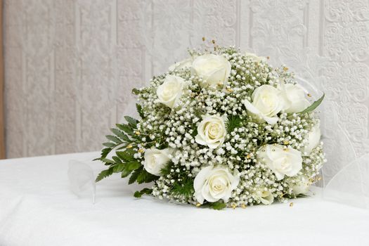 a beautiful bouquet of white roses lay on a table