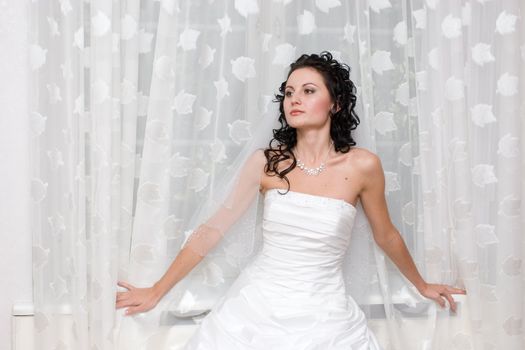 bride stands by the window