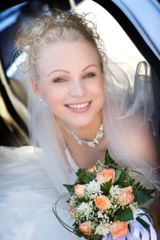 Portrait of the bride sitting in the car