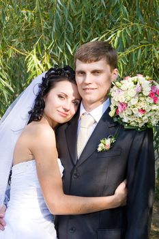 a beautiful brunette bride embraces a groom with love