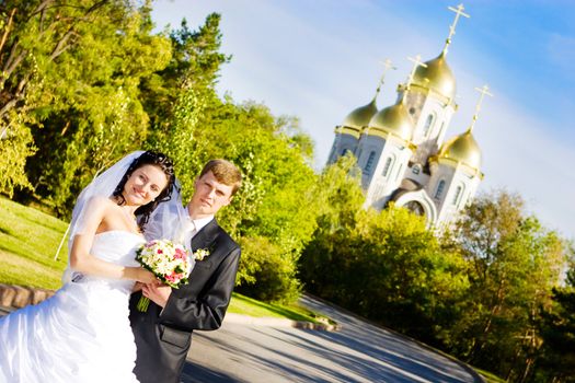 a happy bride and a groom near the church