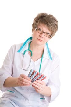 The woman in a white gown holds four packings with medicine in hands