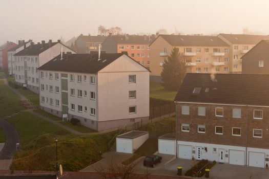 Morning fog in typical German small city suburb of apartment buildings (Germany, Europe).