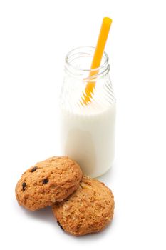 Two oatmeal cookies with peanuts and raisins. Near the glass bottle of milk and cocktail straw. Isolated on white background.