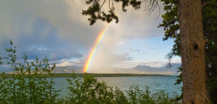 Summer Thundershower resulting in a rainbow over pristine Lake Laberge, Yukon Territory, Canada.
